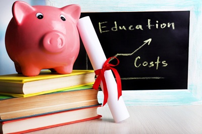 A picture of a piggy bank holding up a diploma, with a blackboard in the background highlighting the rising costs of education.