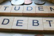 A picture of the words "Student Debt" on a table surrounded by coins