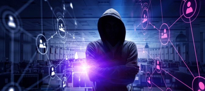 A hooded man in front of a number of computers in the dark web