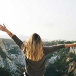 A girl raising her hands up happy to receive student loan forgiveness