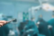 An anesthesiologist with a clipboard in an operating room